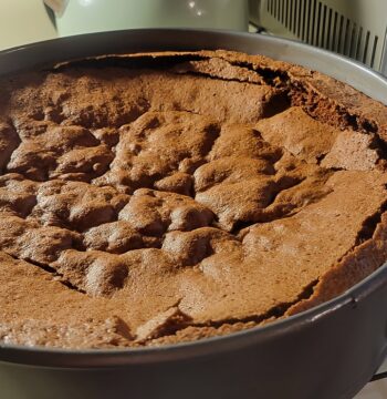 baked chocolate torte in spring form pan, showing crisp and cracked crust on top