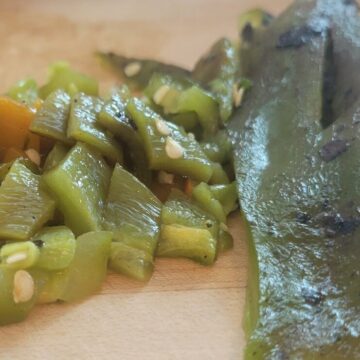 close up of roasted green chili, whole and chopped