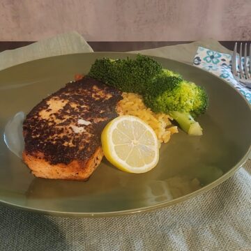 plated salmon, with rice, broccoli, and lemon slice garnish