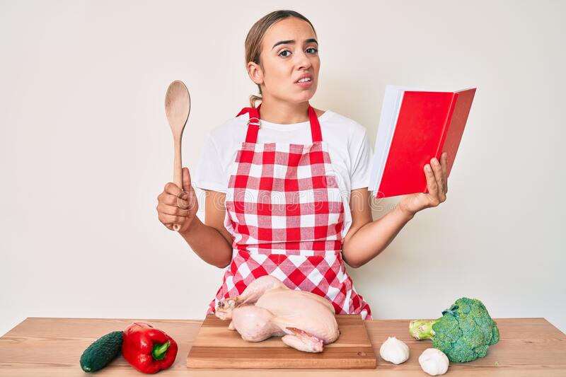 Lady reading  a recipe book looking confused