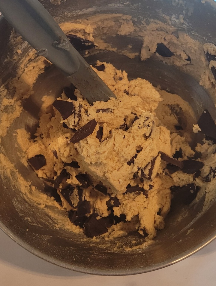 folding chocolate chunks into finished dough