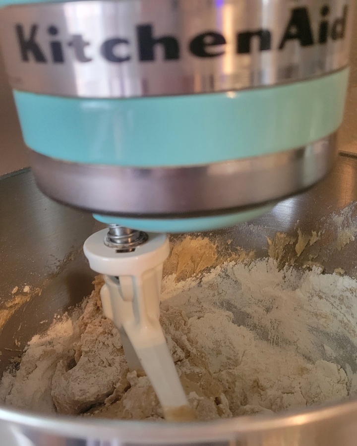 adding dry ingredients to form dough in mixer