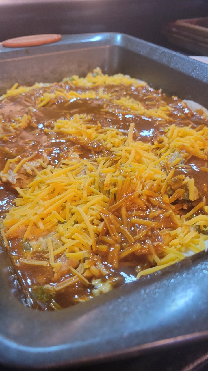 layered chicken enchilada casserole, ready for oven
