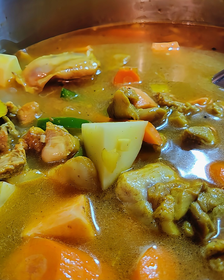 close up of chicken curry in pot, not yet cooked.
