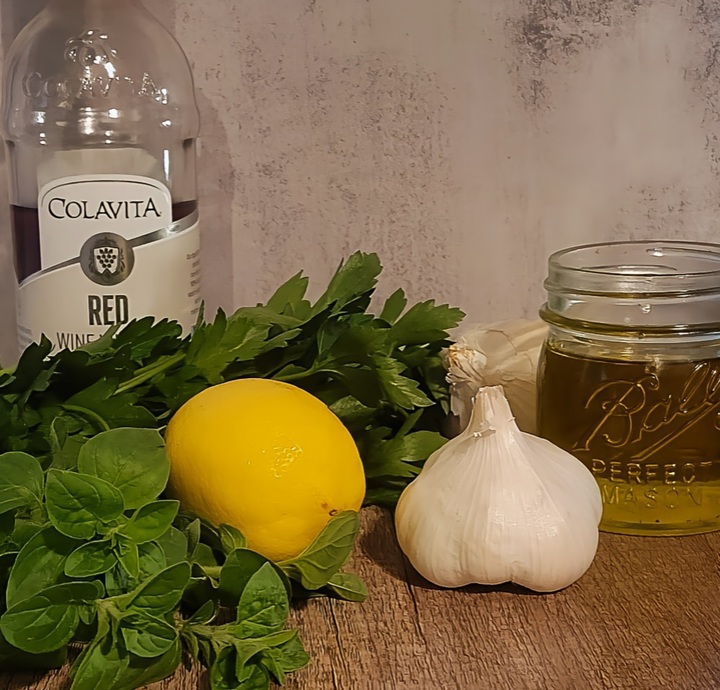 chimichurri ingredients; fresh oregano, parsley, lemon, garlic, olive oil and red wine vinegar