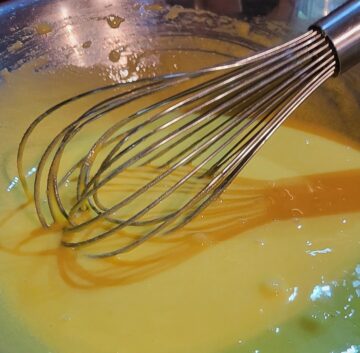 egg yolk and sugar mixture in mixing bowl with wire whip