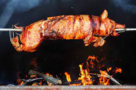 whole pig roasting on spit