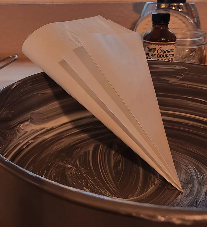 buttered springform pan with parchment paper leaning inside , folded into a triangle