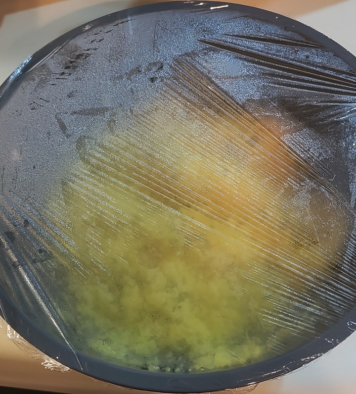 couscous shown in bowl with plastic wrap over it to steam