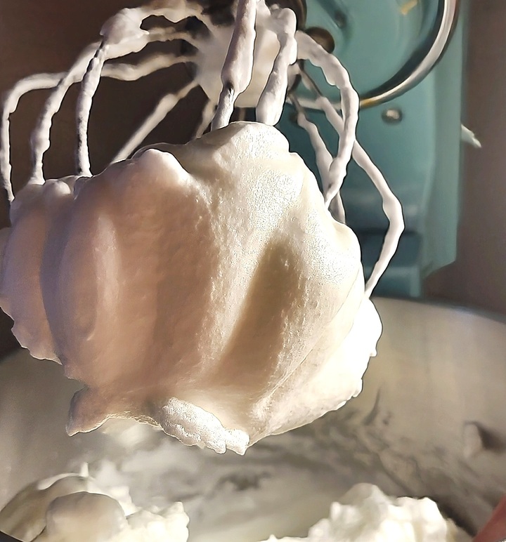 stiffened beaten egg whites shown on whip attachment of stand mixer
flourless chocolate torte