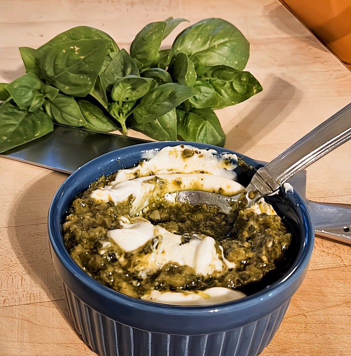 mayo and pesto being stirred with a spoon