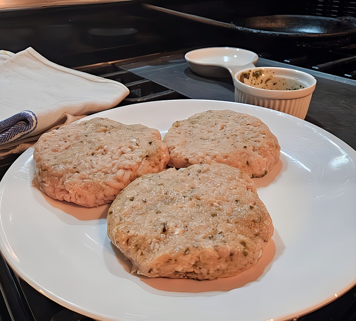 chicken burger patties on a plate, raw.