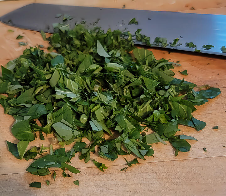 rough chopped oregano on cutting board with knife in background