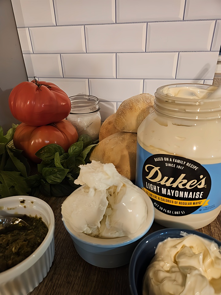 chicken burger ingredients, minus the chicken itself. pesto, fresh mozzarella, mayo, ciabatta buns, basil, heirloom tomato